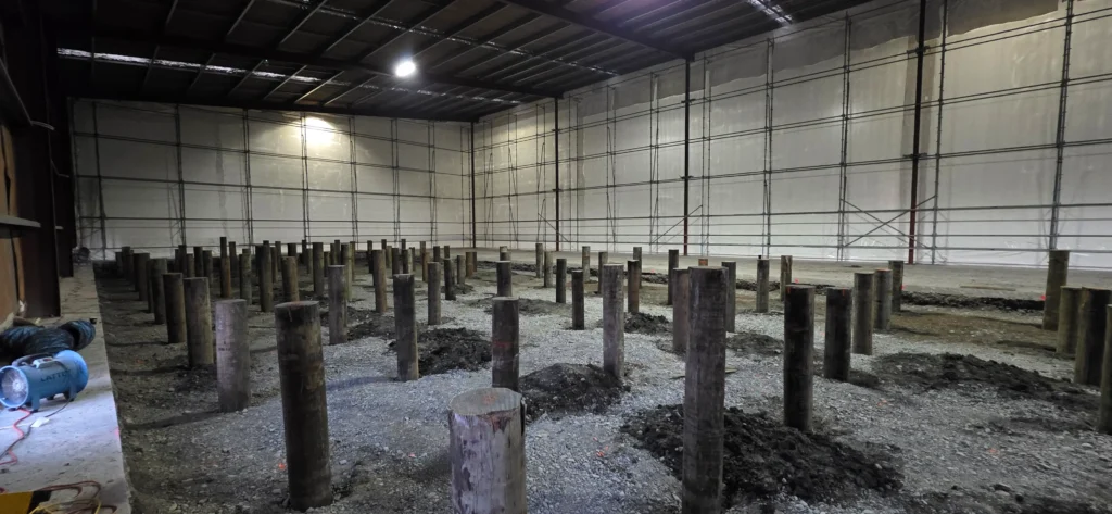 Warehouse interior with rows of timber piles set into the ground