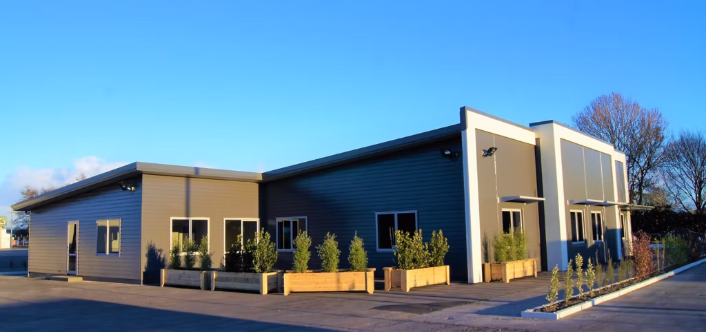 Modern single-storey commercial building with planter boxes along the frontage